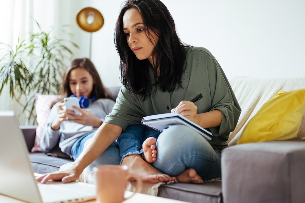 Eine Frau organisiert ihre Finanzen zu Hause auf dem Sofa.